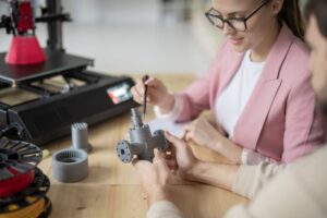 Business owner reviewing a 3D printed part for quality